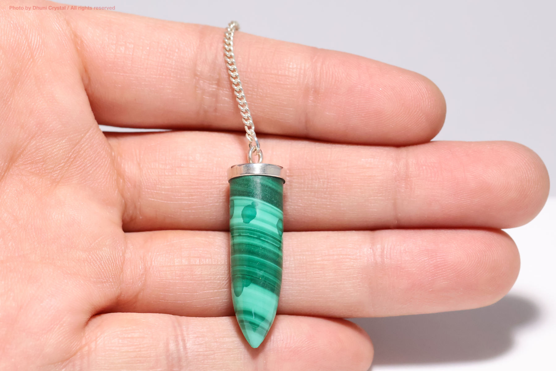 マラカイトペンジュラム手の上の画像